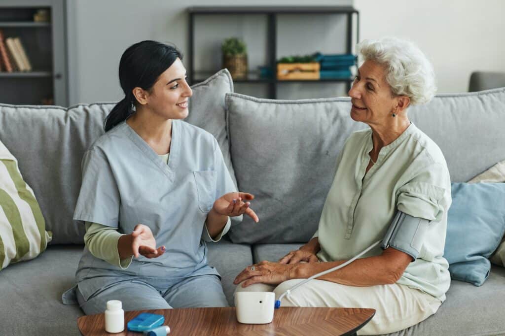 Young Nurse Talking to Senior Woman in Retirement Home