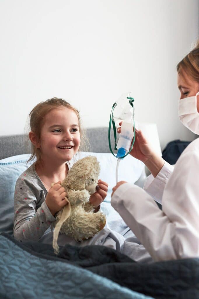 Doctor visiting little patient at home. Child having medical inhalation treatment with nebuliser
